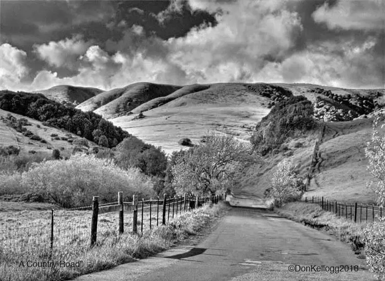 black and white photo of hills and road